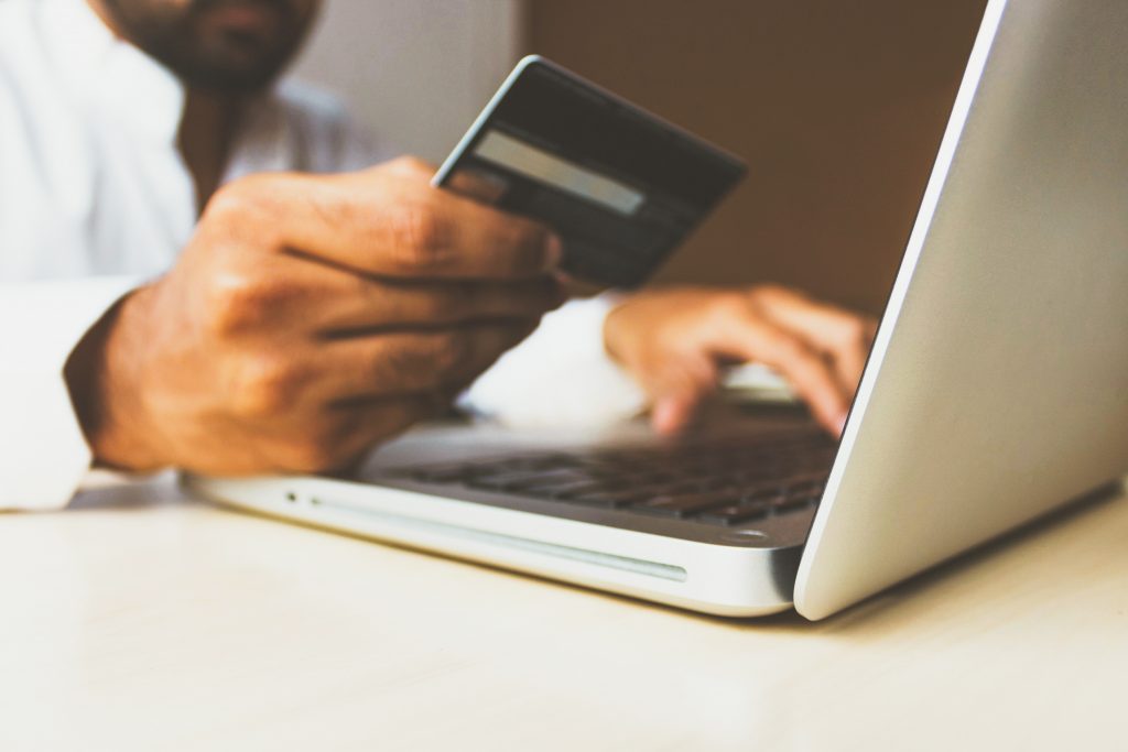 card in front of computer someone places an order online while shopping 