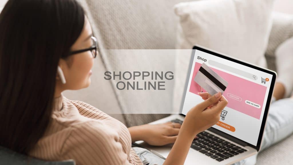 Asian Girl Doing Online Shopping from a shop does not ship outside US, Using Laptop And Credit Card Sitting On Couch At Home.